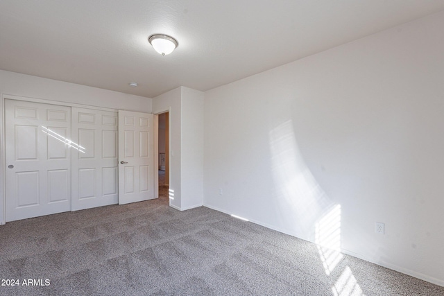 unfurnished bedroom featuring carpet flooring and a closet