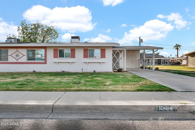 view of front facade featuring concrete driveway, cooling unit, a front yard, a carport, and brick siding