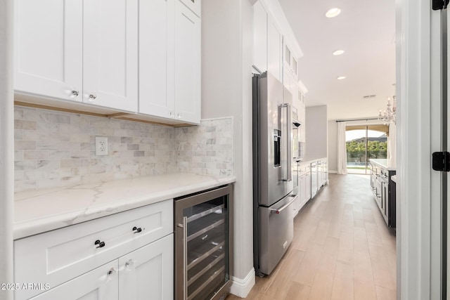 kitchen with white cabinets, decorative backsplash, wine cooler, and high end refrigerator