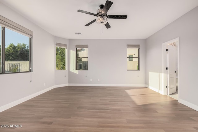 spare room featuring ceiling fan, a healthy amount of sunlight, and light wood-type flooring