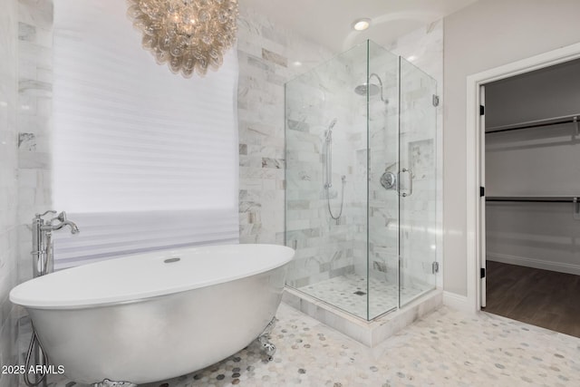 bathroom featuring shower with separate bathtub, an inviting chandelier, and wood-type flooring