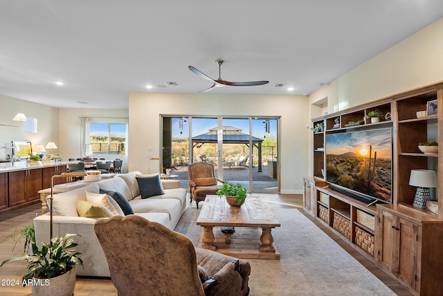 living room featuring ceiling fan, a healthy amount of sunlight, and light hardwood / wood-style flooring