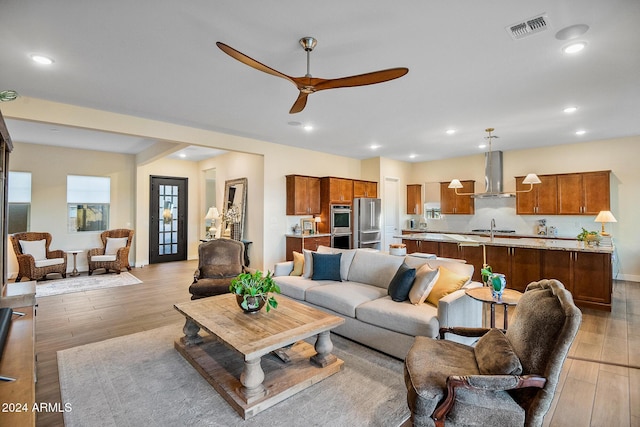 living room featuring light hardwood / wood-style flooring and ceiling fan