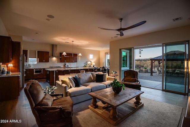 living room with hardwood / wood-style flooring, ceiling fan, and sink