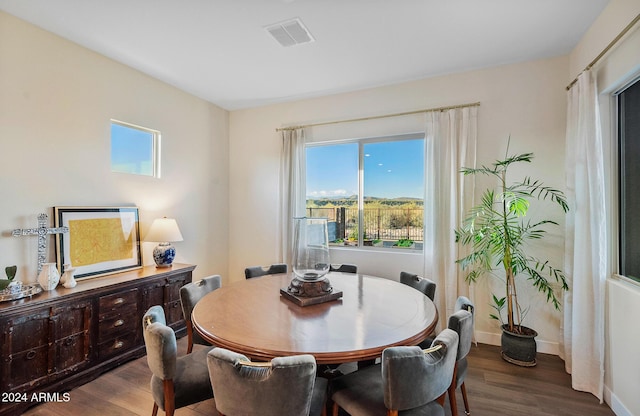 dining space with dark hardwood / wood-style flooring and a healthy amount of sunlight