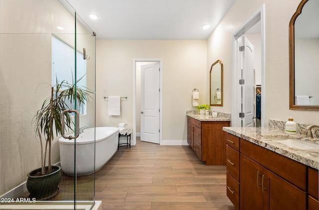 bathroom with a bathtub, vanity, and wood-type flooring