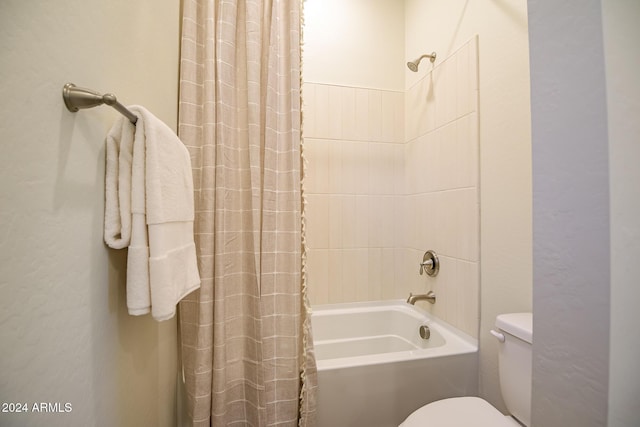 bathroom with shower / bath combination with curtain and toilet