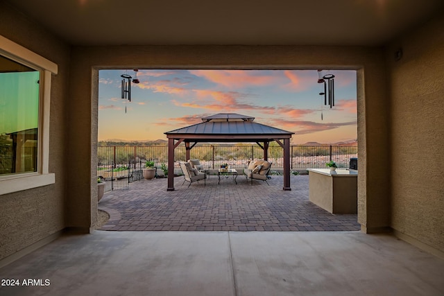 patio terrace at dusk with a gazebo and an outdoor living space