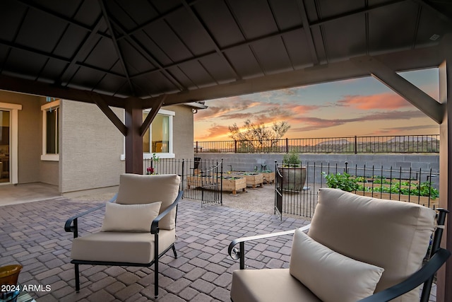 patio terrace at dusk featuring a water view