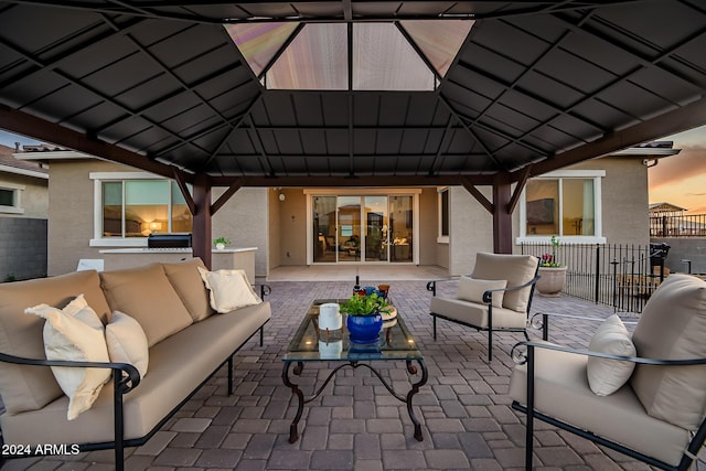 patio terrace at dusk featuring a gazebo and an outdoor living space