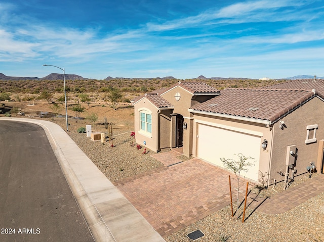 view of front of home with a mountain view and a garage