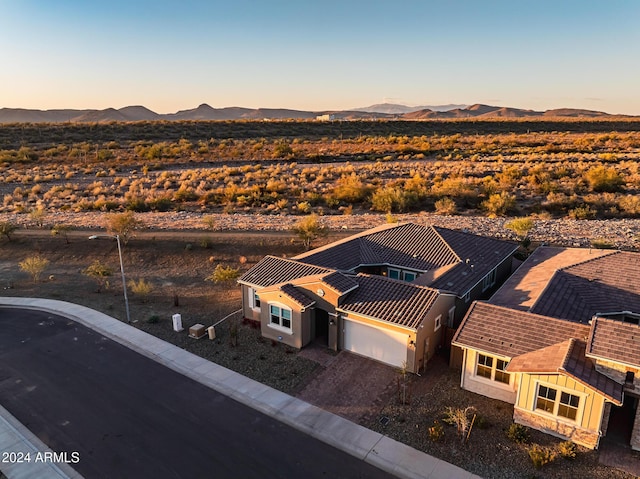 aerial view at dusk featuring a mountain view