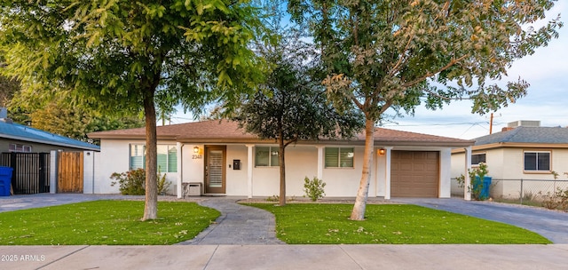 ranch-style home featuring a garage and a front lawn