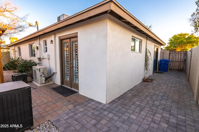 view of exterior entry with a patio and ac unit