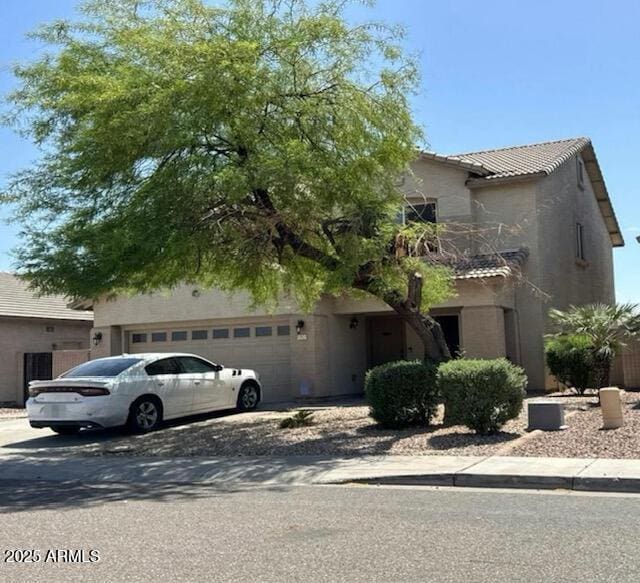11633 W Jefferson St, Avondale, AZ 85323 - view of property hidden behind natural elements with stucco siding, a tiled roof, a garage, and concrete driveway