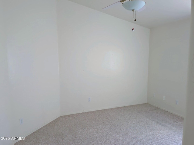 carpeted spare room with a ceiling fan