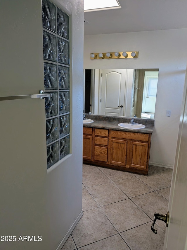 bathroom with a sink, double vanity, and tile patterned flooring