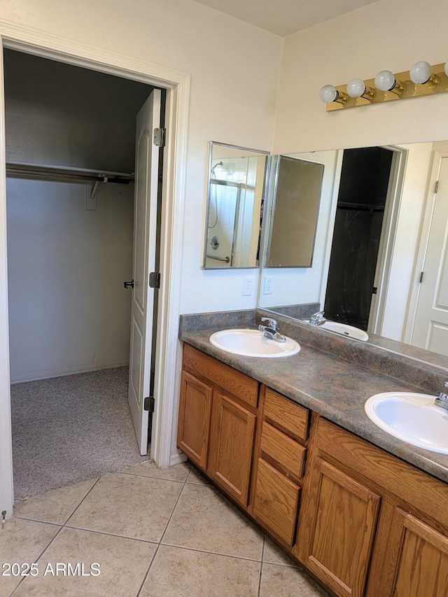 full bathroom with double vanity, tile patterned flooring, and a sink