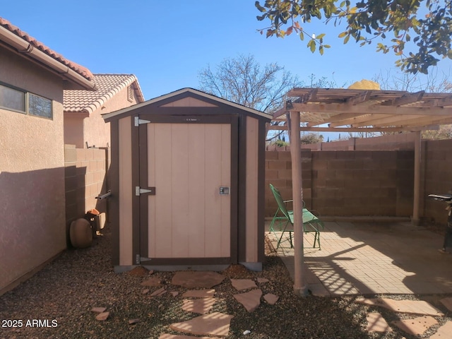 view of shed with a pergola and a fenced backyard