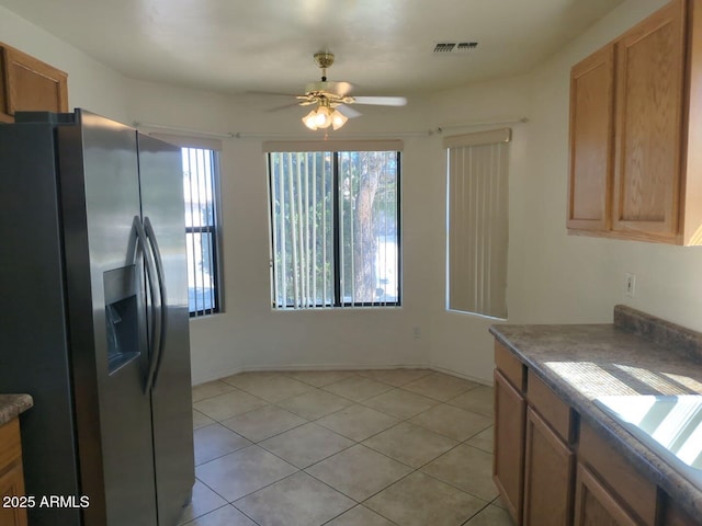 kitchen featuring a ceiling fan, visible vents, light tile patterned flooring, stainless steel fridge with ice dispenser, and a sink