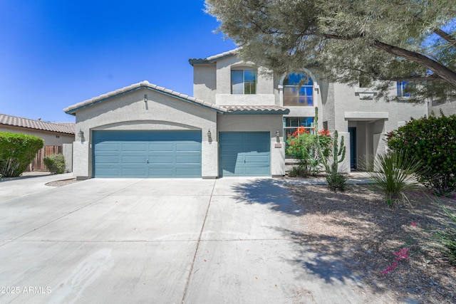 14430 W Windsor Ave, Goodyear, AZ 85395 - mediterranean / spanish-style home with stucco siding, concrete driveway, a tile roof, an attached garage, and fence