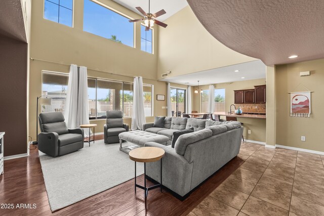 14430 W Windsor Ave, Goodyear, AZ 85395 - living area with a ceiling fan, plenty of natural light, baseboards, a towering ceiling, and recessed lighting
