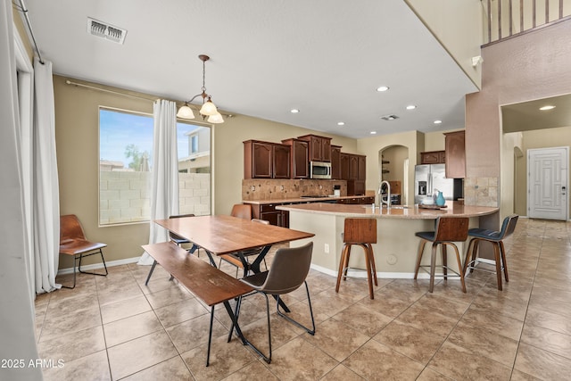 14430 W Windsor Ave, Goodyear, AZ 85395 - dining space with light tile patterned flooring, arched walkways, recessed lighting, and baseboards