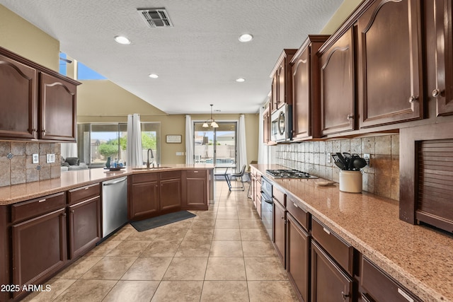 14430 W Windsor Ave, Goodyear, AZ 85395 - kitchen with stainless steel appliances, a sink, backsplash, light tile patterned flooring, and a peninsula