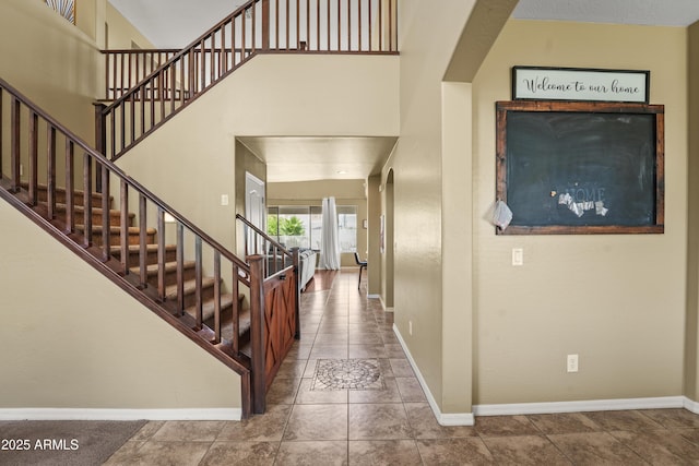 14430 W Windsor Ave, Goodyear, AZ 85395 - entryway featuring baseboards, stairs, tile patterned floors, and a towering ceiling