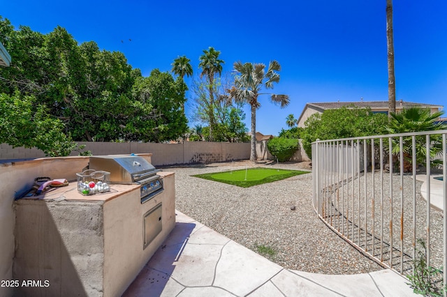 14430 W Windsor Ave, Goodyear, AZ 85395 - fenced backyard with area for grilling, a putting green, and a patio area