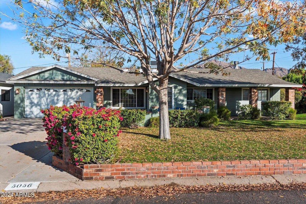 ranch-style home with a front yard and a garage