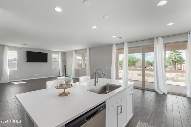 kitchen featuring a center island with sink, a healthy amount of sunlight, and sink