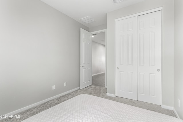 bedroom with light carpet and a closet