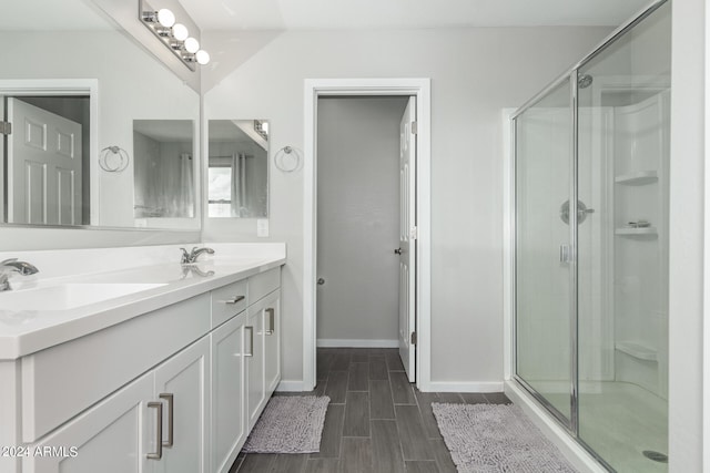 bathroom with wood-type flooring, a shower with shower door, and vanity