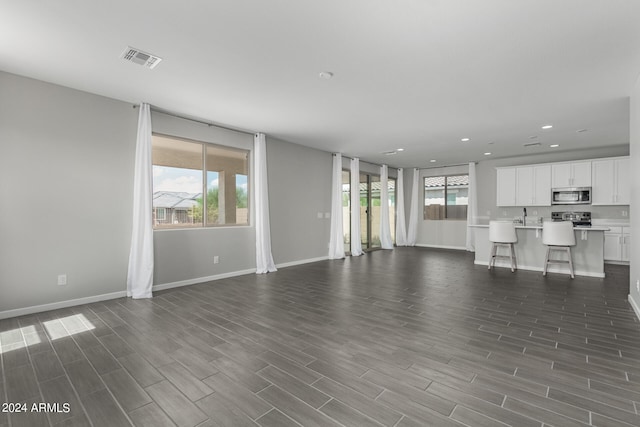 unfurnished living room with dark hardwood / wood-style flooring