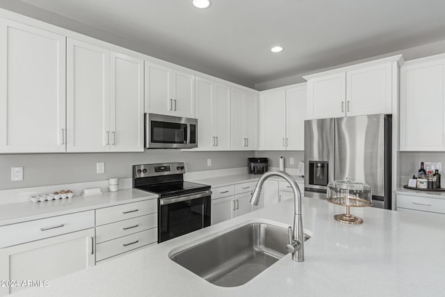 kitchen featuring appliances with stainless steel finishes, sink, and white cabinets