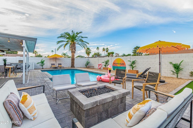 view of pool with a patio and an outdoor living space with a fire pit