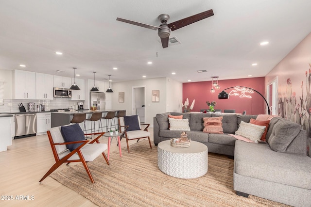 living room featuring light hardwood / wood-style flooring and ceiling fan