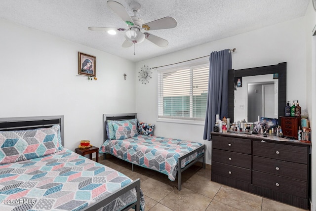 bedroom with a textured ceiling, ceiling fan, and light tile patterned flooring