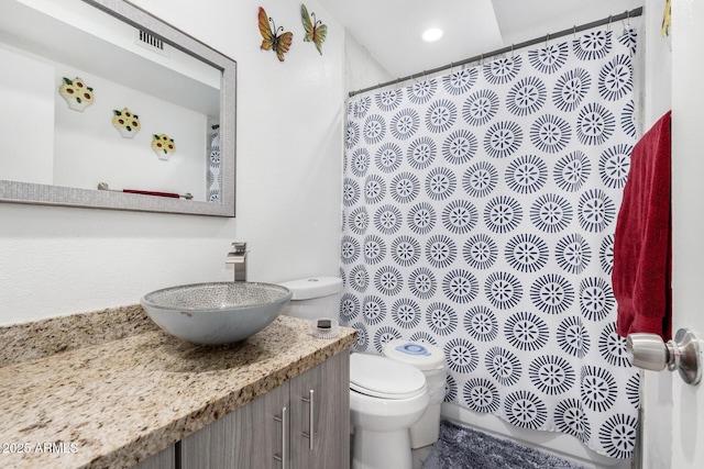 bathroom with toilet, visible vents, curtained shower, and vanity