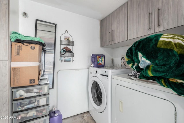 clothes washing area featuring cabinet space and independent washer and dryer