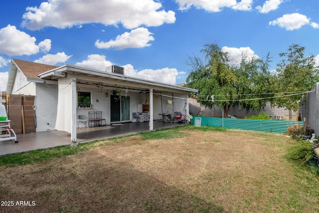 rear view of property with a lawn, fence, and a patio area