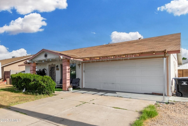 ranch-style house featuring concrete driveway, a garage, and stucco siding