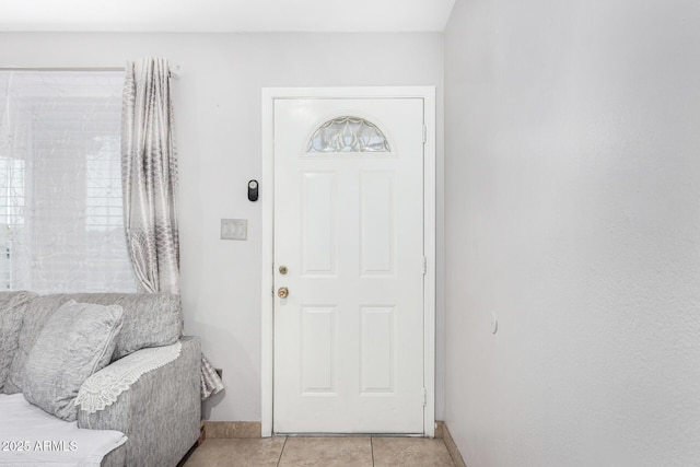 foyer with light tile patterned floors and baseboards