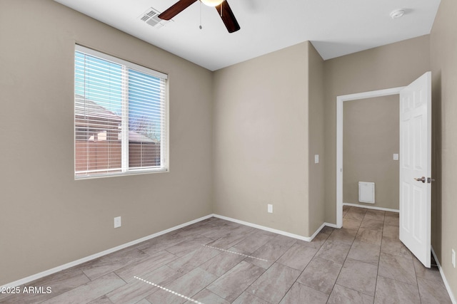 unfurnished room with visible vents, a ceiling fan, and baseboards