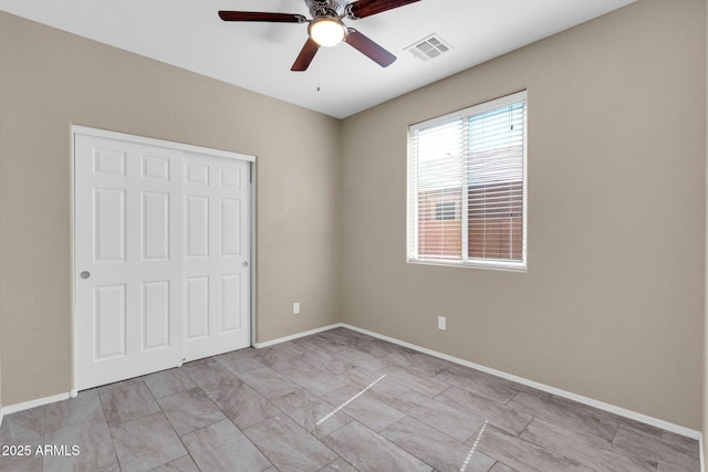 unfurnished bedroom with visible vents, ceiling fan, and baseboards