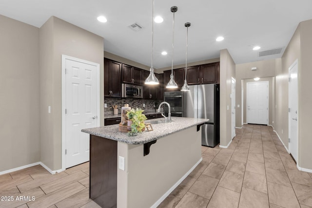 kitchen featuring a sink, dark brown cabinetry, visible vents, and stainless steel appliances