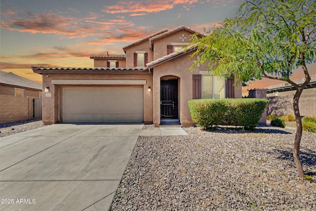 view of front of property featuring stucco siding, concrete driveway, an attached garage, and fence