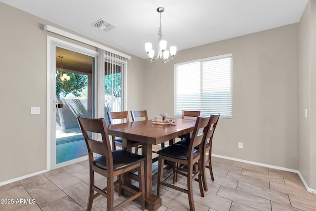 dining area featuring a notable chandelier, a healthy amount of sunlight, and visible vents