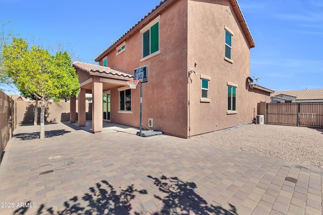 back of property with a tile roof, a patio area, a fenced backyard, and stucco siding